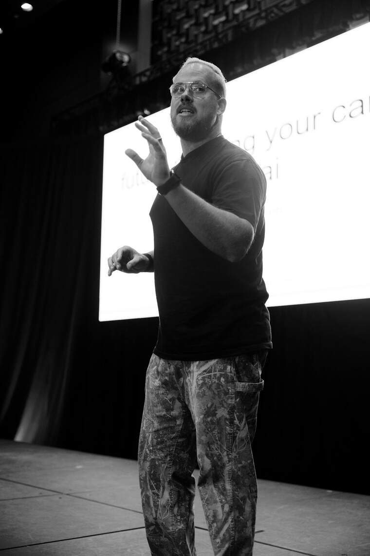 taylor desseyn speaking on stage at all things open